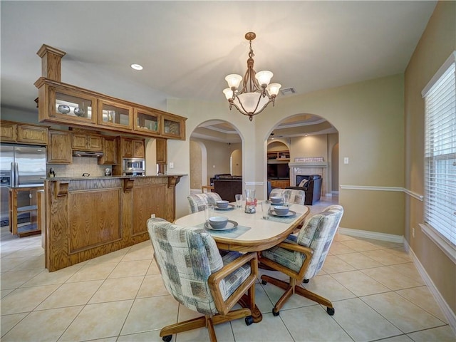 tiled dining area featuring a chandelier