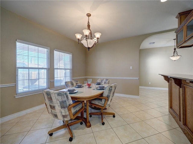 tiled dining area with a chandelier