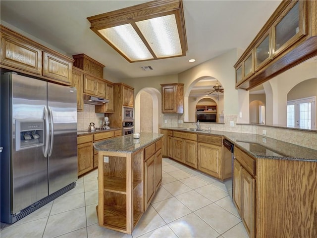 kitchen with kitchen peninsula, a center island, stainless steel appliances, and tasteful backsplash