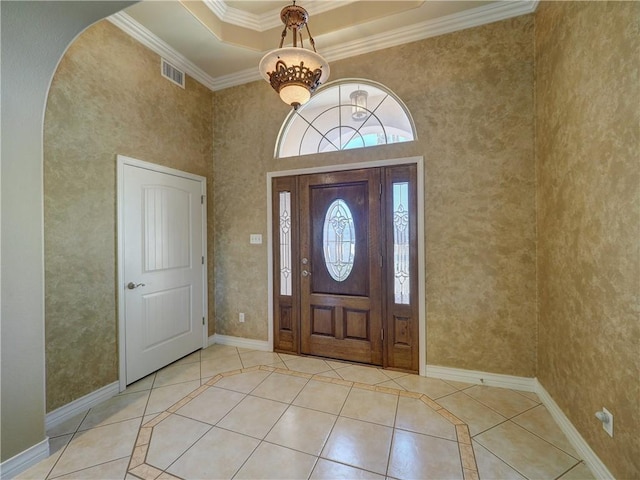 foyer featuring arched walkways, visible vents, baseboards, and light tile patterned flooring