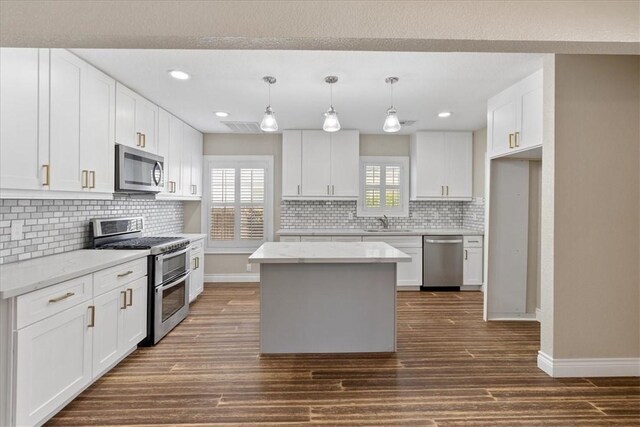 524 Del Mar, Corpus Christi, TX 78404 - kitchen with appliances with stainless steel finishes, dark wood-style flooring, decorative backsplash, white cabinetry, and recessed lighting