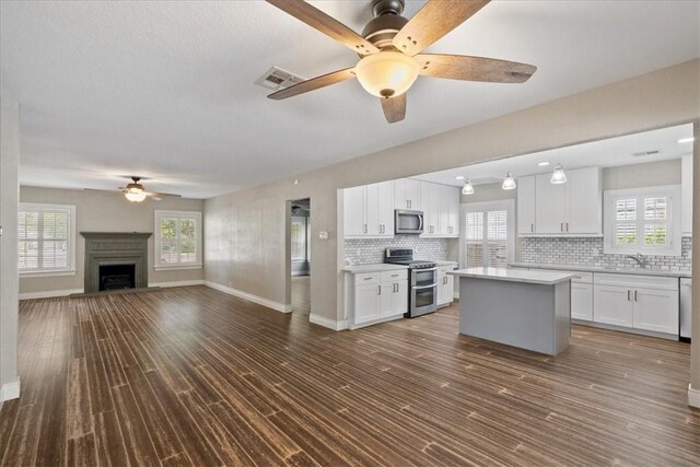 524 Del Mar, Corpus Christi, TX 78404 - kitchen with stainless steel appliances, ceiling fan, a sink, and white cabinets