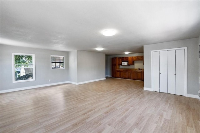 524 Del Mar, Corpus Christi, TX 78404 - unfurnished living room with light wood-style flooring and baseboards
