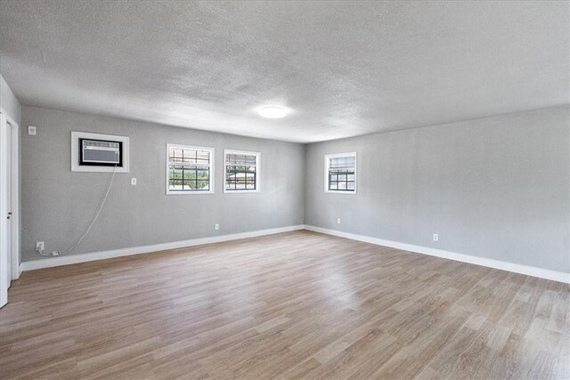 524 Del Mar, Corpus Christi, TX 78404 - empty room featuring a textured ceiling, light wood-type flooring, healthy amount of natural light, and baseboards