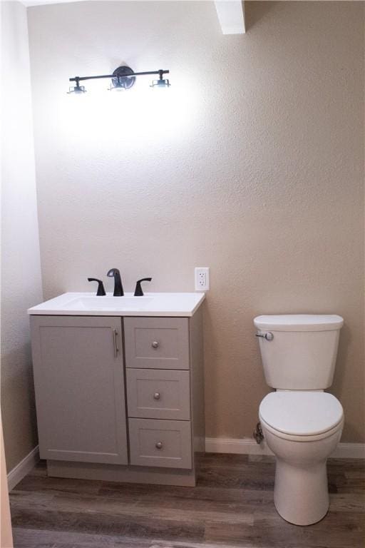 bathroom with hardwood / wood-style flooring, vanity, and toilet