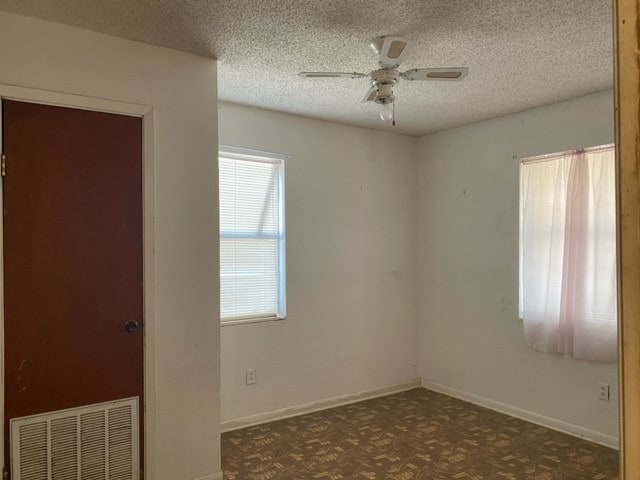 spare room with a textured ceiling and ceiling fan