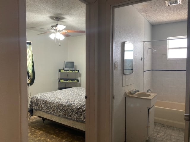 bedroom featuring a textured ceiling, ceiling fan, and sink