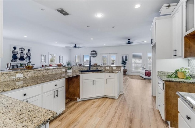 kitchen featuring plenty of natural light, light wood-type flooring, a sink, and visible vents