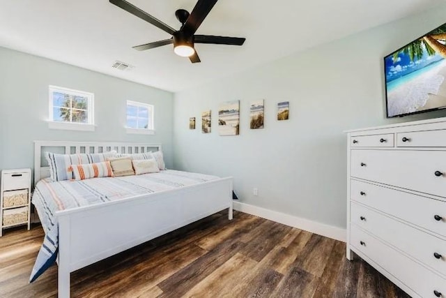 bedroom featuring visible vents, dark wood finished floors, baseboards, and ceiling fan