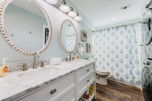 full bathroom with toilet, wood finished floors, a sink, and visible vents