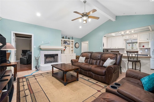 tiled living room featuring ceiling fan, lofted ceiling with beams, and a fireplace