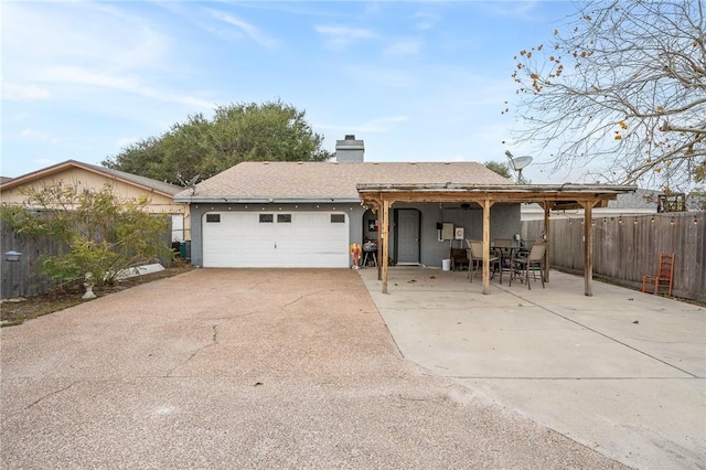 single story home featuring a garage and a patio