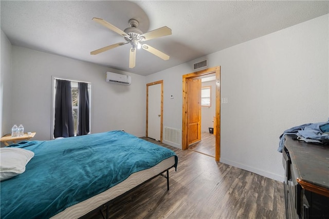 bedroom with a wall mounted AC, ceiling fan, and dark hardwood / wood-style floors