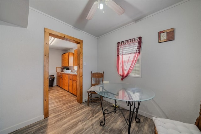 dining room with ceiling fan, light wood-type flooring, and crown molding