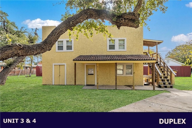 rear view of house with a patio area and a yard