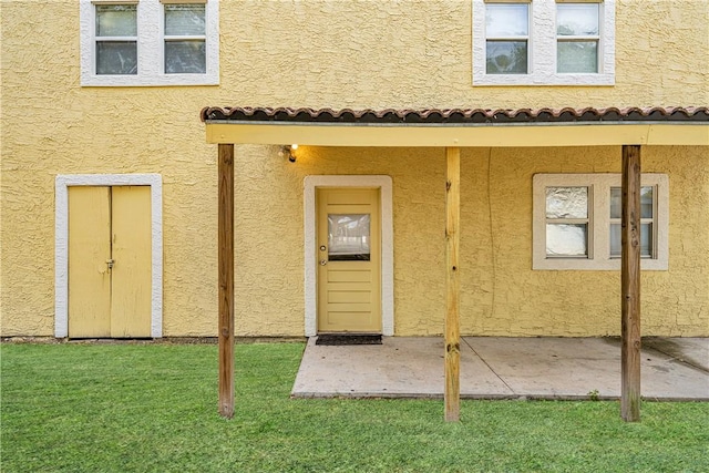 entrance to property featuring a lawn