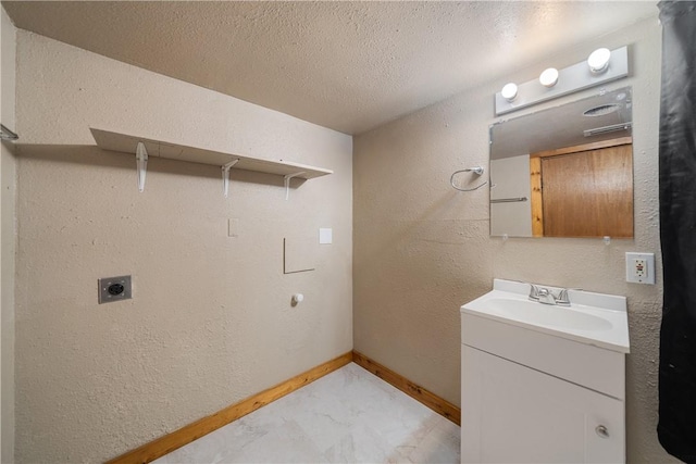 laundry room featuring hookup for an electric dryer, a textured ceiling, and sink