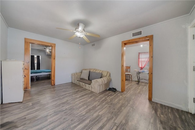 sitting room with hardwood / wood-style flooring, ceiling fan, and crown molding