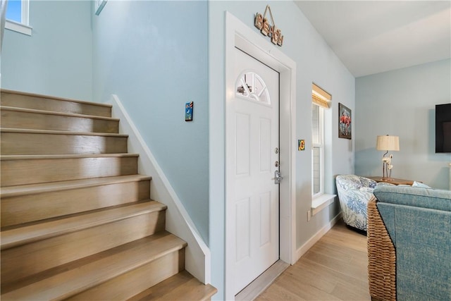 staircase featuring baseboards and wood finished floors