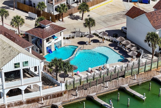 pool featuring a floating dock, a patio, and fence