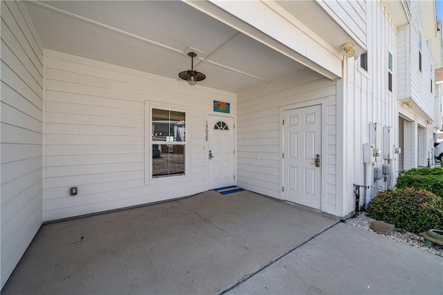 view of exterior entry with a patio area