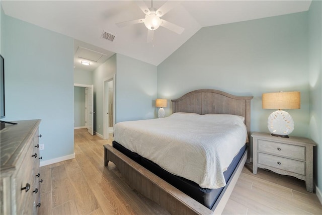 bedroom with visible vents, baseboards, attic access, light wood-type flooring, and vaulted ceiling