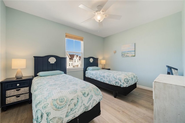 bedroom featuring a ceiling fan, baseboards, and wood finished floors