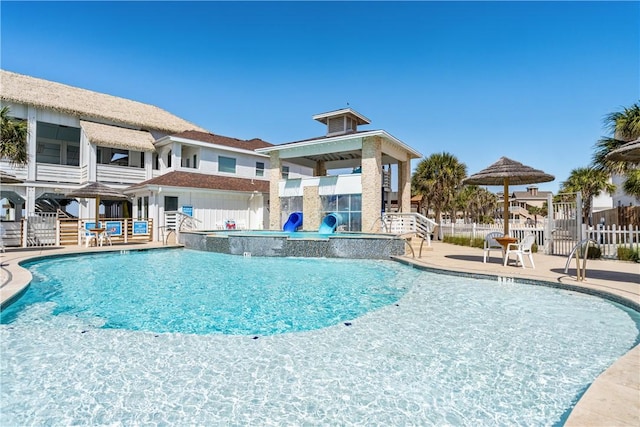 pool with a patio and fence