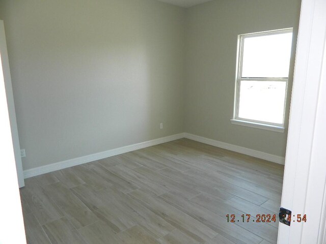 empty room with light hardwood / wood-style flooring