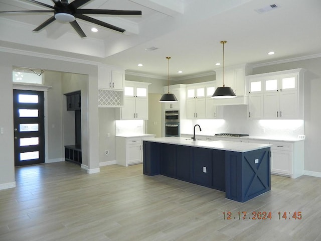 kitchen with decorative light fixtures, white cabinetry, and a kitchen island with sink