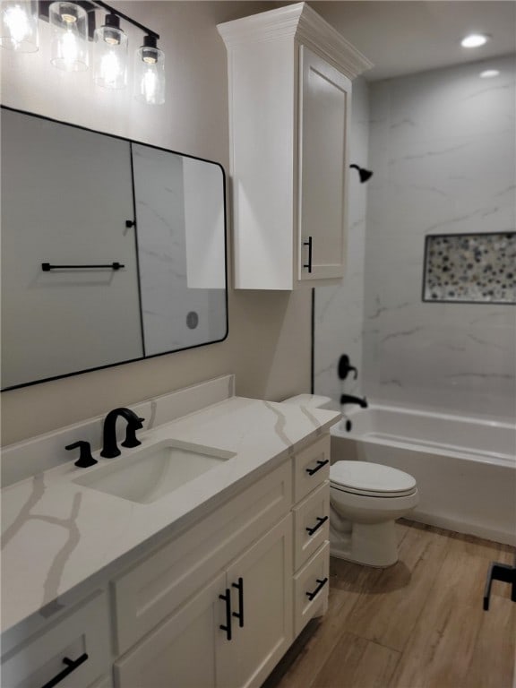 full bathroom with vanity, toilet, tiled shower / bath combo, and wood-type flooring