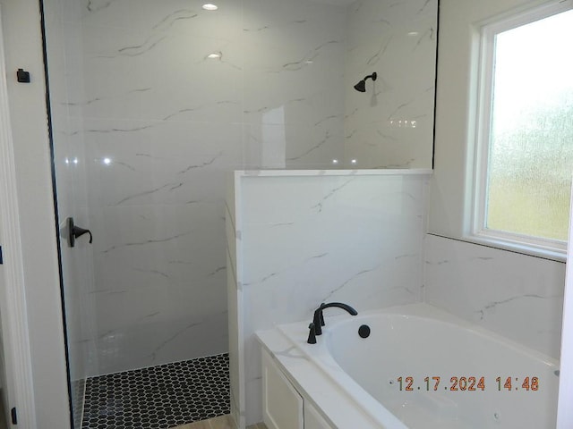 bathroom with independent shower and bath and plenty of natural light