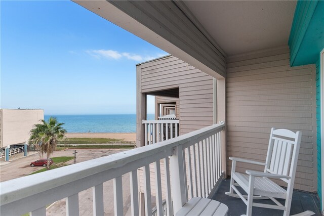 balcony featuring a view of the beach and a water view