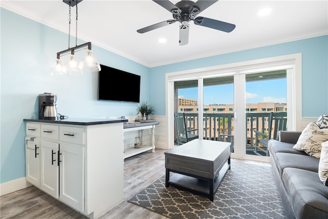 living room with light wood-type flooring, ceiling fan, and crown molding