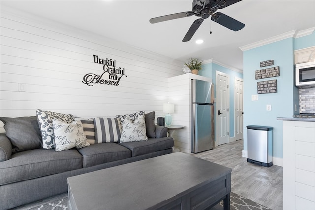 living room with hardwood / wood-style floors, ceiling fan, and crown molding