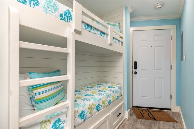 bedroom with a closet, wood-type flooring, and crown molding