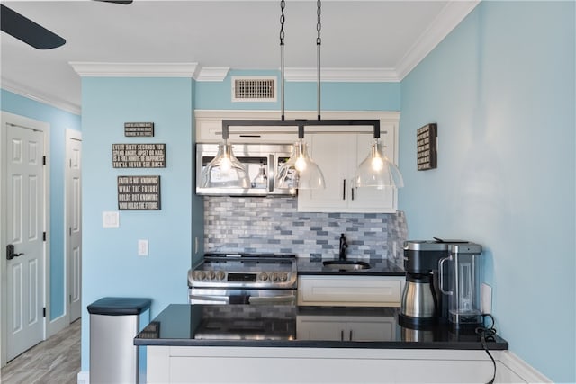 kitchen featuring white cabinetry, appliances with stainless steel finishes, sink, and decorative light fixtures