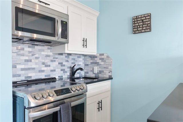 kitchen featuring decorative backsplash, white cabinetry, sink, and stainless steel appliances