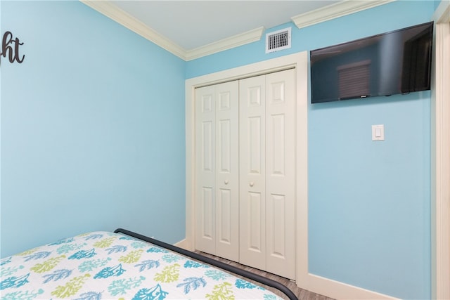 unfurnished bedroom with ornamental molding, hardwood / wood-style floors, and a closet