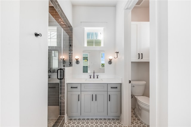 bathroom with vanity, toilet, and a shower with shower door