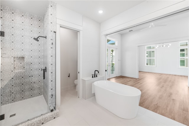 bathroom with toilet, plus walk in shower, wood-type flooring, and ceiling fan