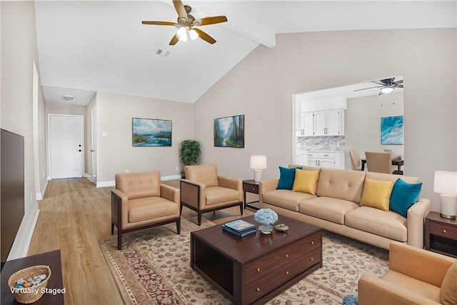 living room with light wood-type flooring, ceiling fan, beam ceiling, and high vaulted ceiling