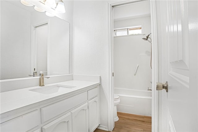 full bathroom with shower / bathing tub combination, vanity, toilet, and hardwood / wood-style flooring