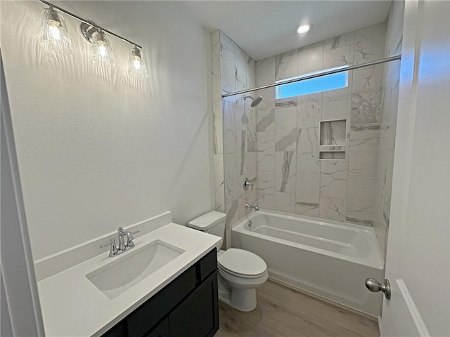 full bathroom featuring toilet, vanity, tiled shower / bath combo, and hardwood / wood-style flooring