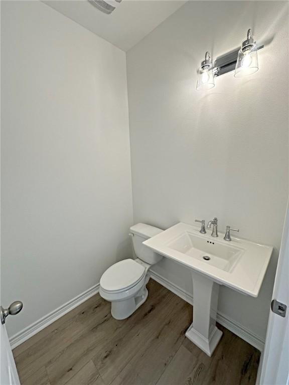 bathroom featuring hardwood / wood-style floors and toilet