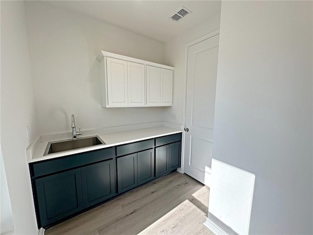 interior space featuring sink, white cabinets, and light hardwood / wood-style floors