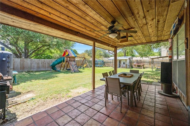 10637 Westwood Dr, Corpus Christi, TX 78410 - fenced backyard with a patio, a storage shed, outdoor dining space, a playground, and a ceiling fan