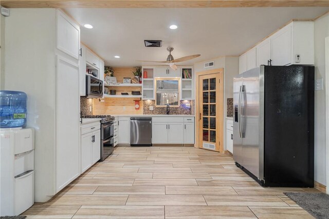 10637 Westwood Dr, Corpus Christi, TX 78410 - kitchen with stainless steel appliances, open shelves, white cabinets, recessed lighting, and backsplash