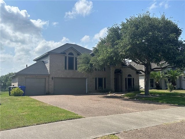 6333 Oso Pkwy, Corpus Christi, TX 78414 - view of front of home with driveway, a front lawn, brick siding, and an attached garage