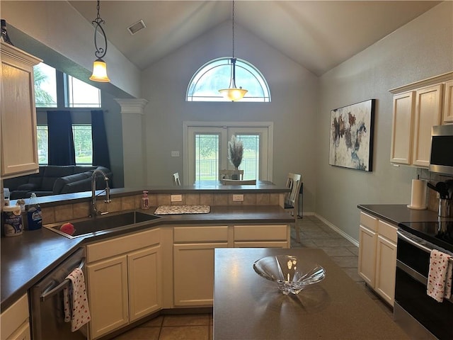 6333 Oso Pkwy, Corpus Christi, TX 78414 - kitchen with appliances with stainless steel finishes, a sink, light tile patterned flooring, dark countertops, and high vaulted ceiling